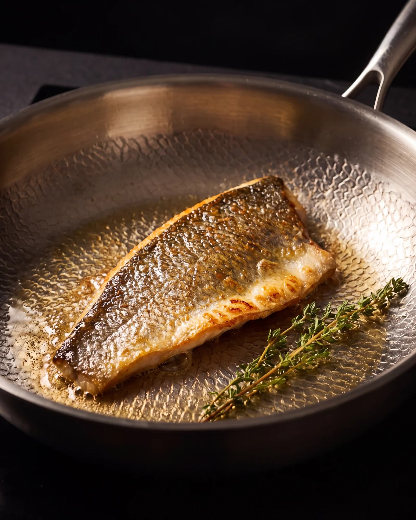 A fillet of fish cooking skin-side down