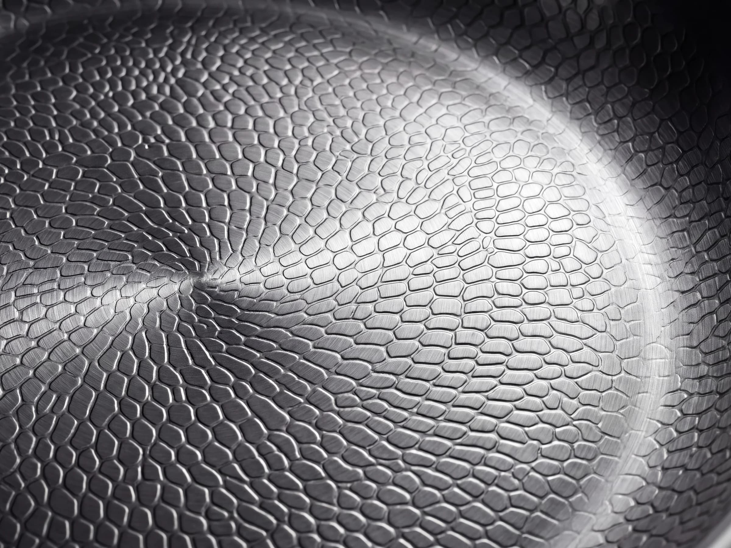 Macro detail of the hammered titanium surface under side light